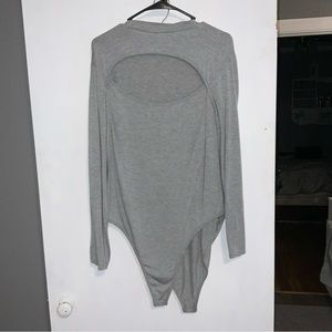 Grey body suit with large oval opening on the chest